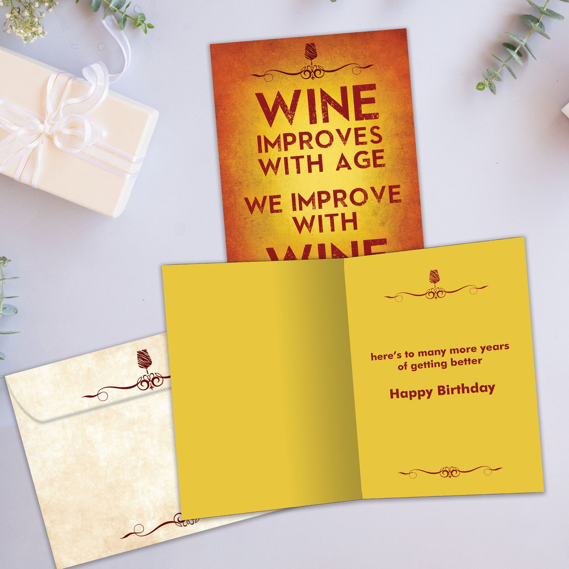 Front and inside view of a Birthday greeting card showcasing "Wine improves with age, we improve with wine," with a matching envelope.