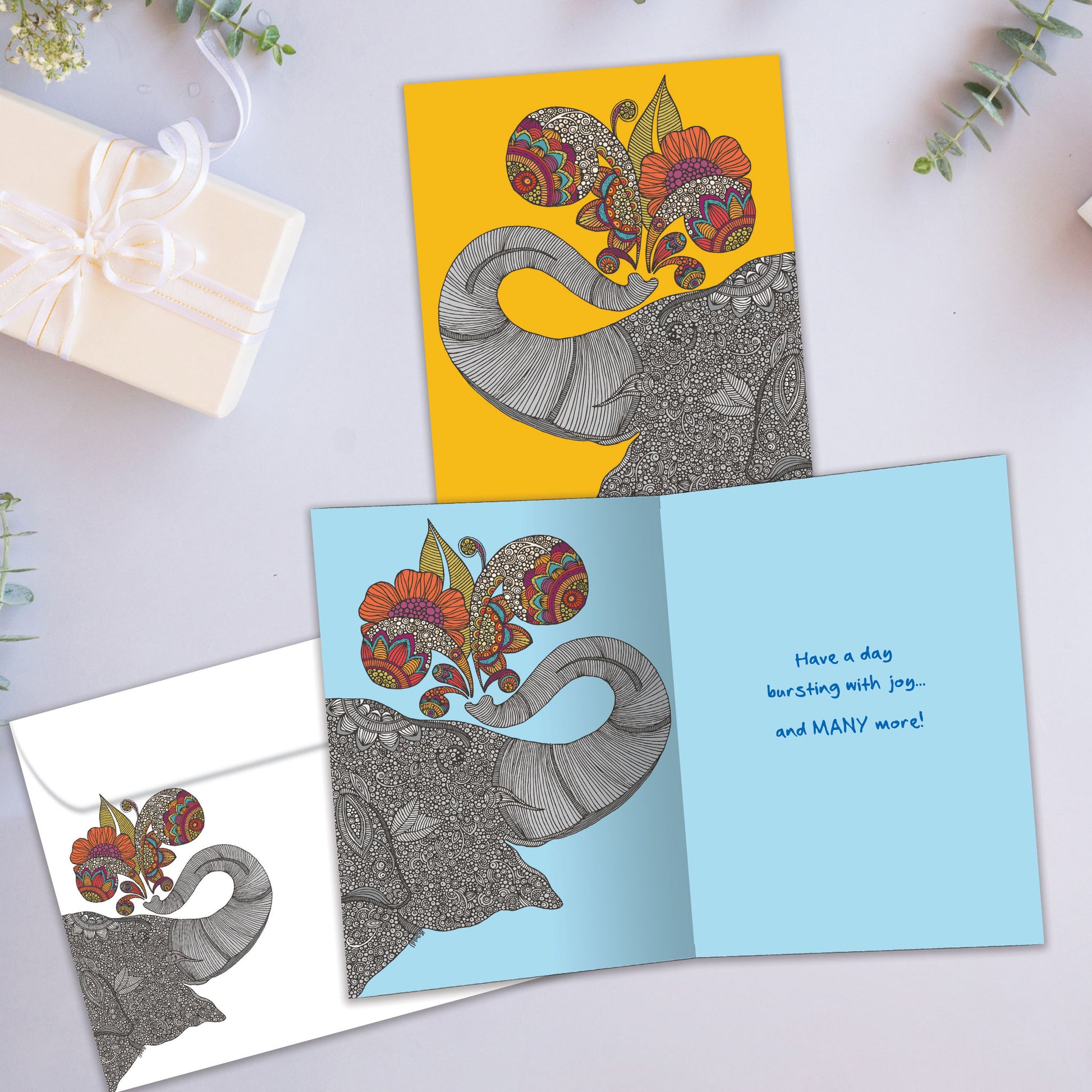 Front and inside view of a Birthday greeting card showcasing a happy elephant on an amber background, with a matching envelope.