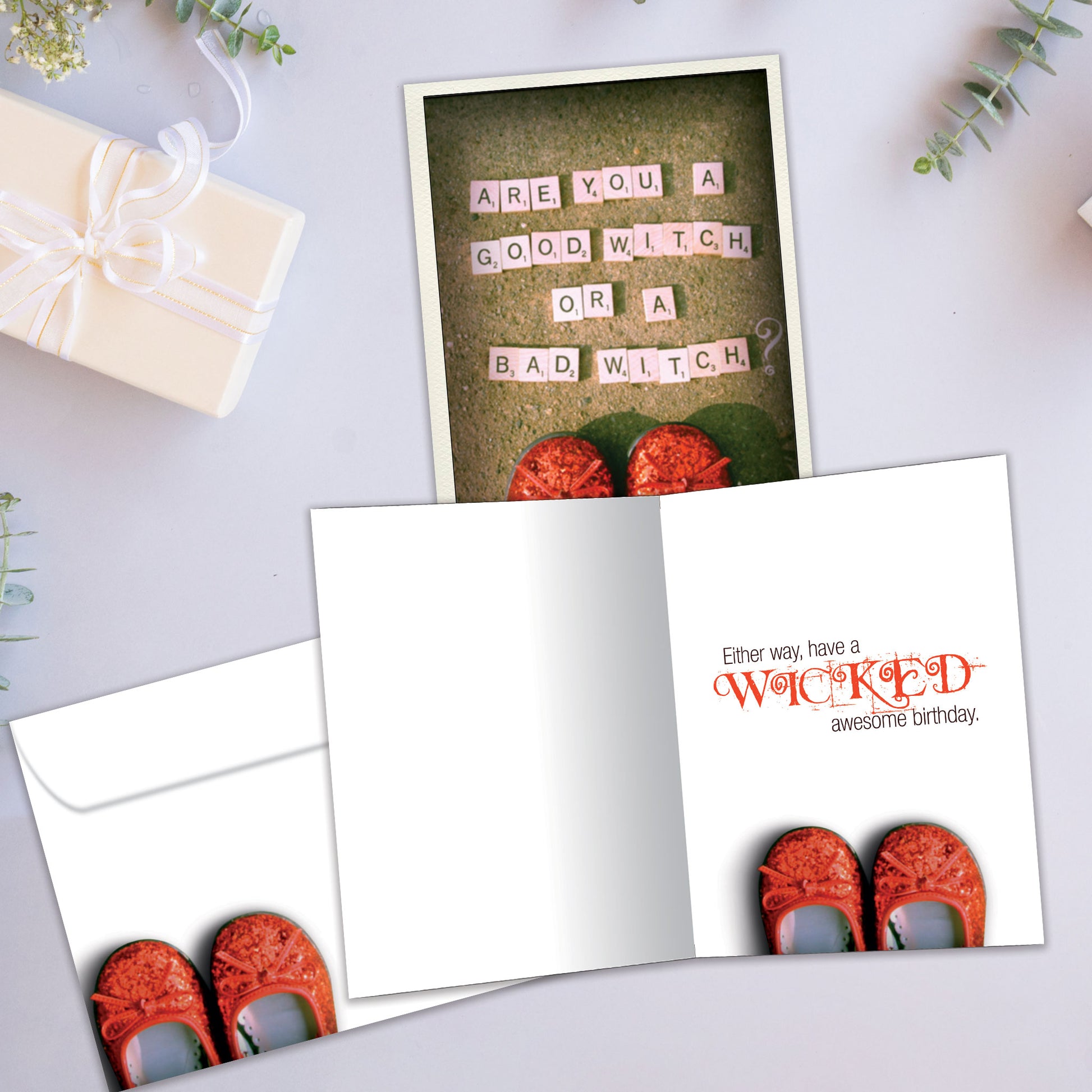 Front and inside view of a Birthday greeting card showcasing ruby red shoes and a playful witch-themed message, with a matching envelope.