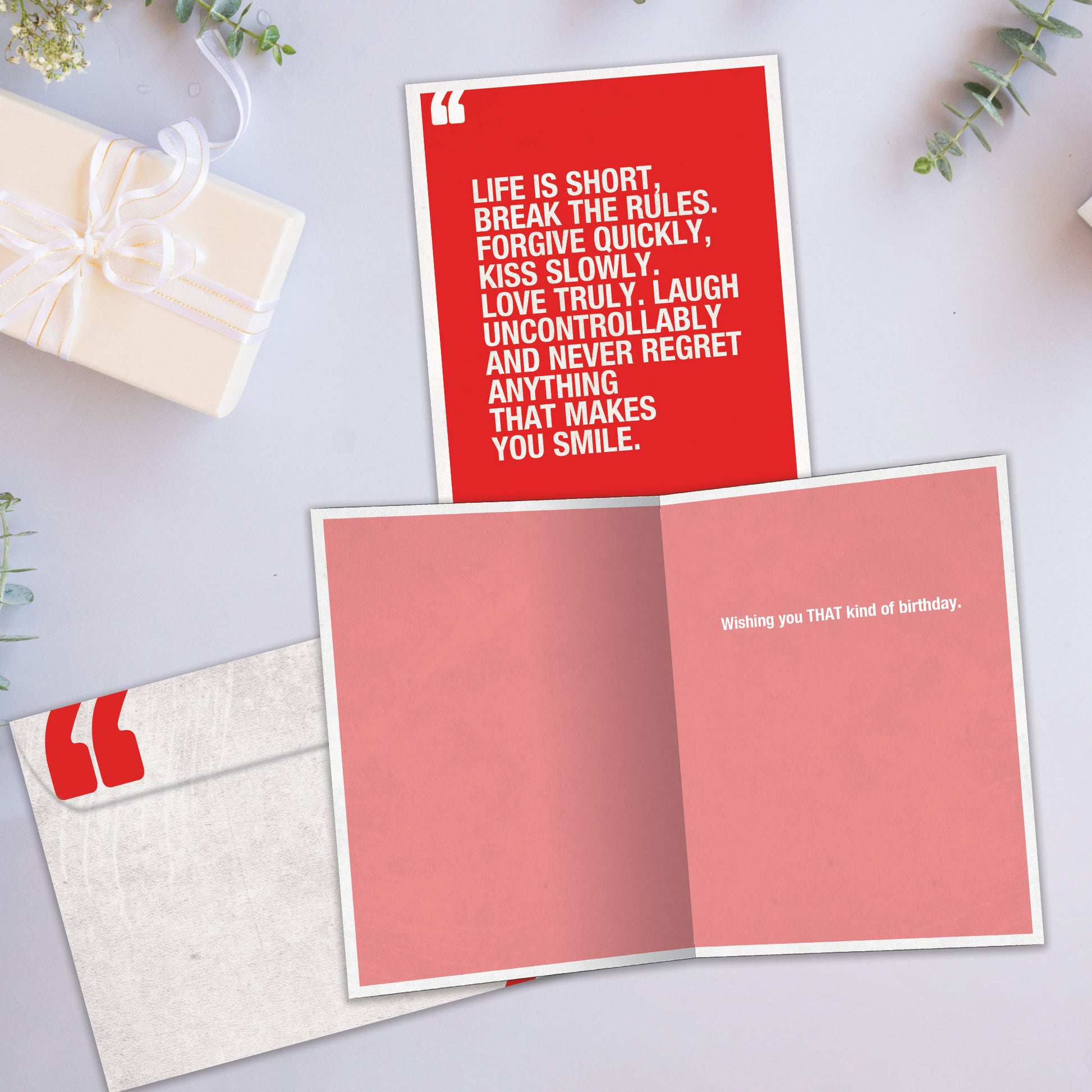 Front and inside view of a Birthday greeting card showcasing a red design with a Mark Twain quote in white text, with a matching envelope.