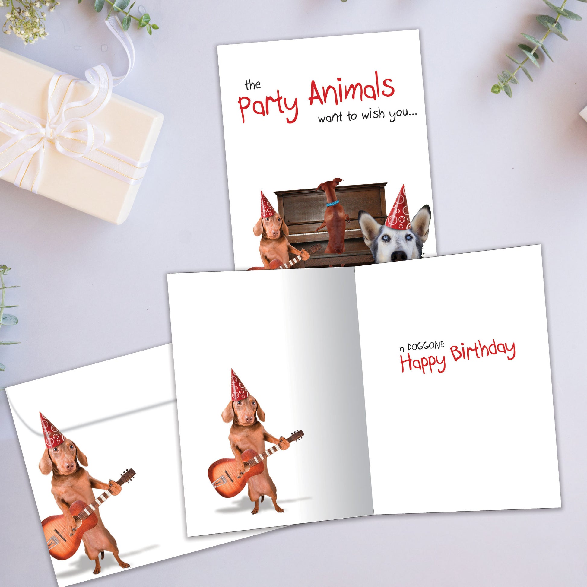 Front and inside view of a Birthday greeting card showcasing a lively scene of dogs partying and playing music, with a matching envelope.