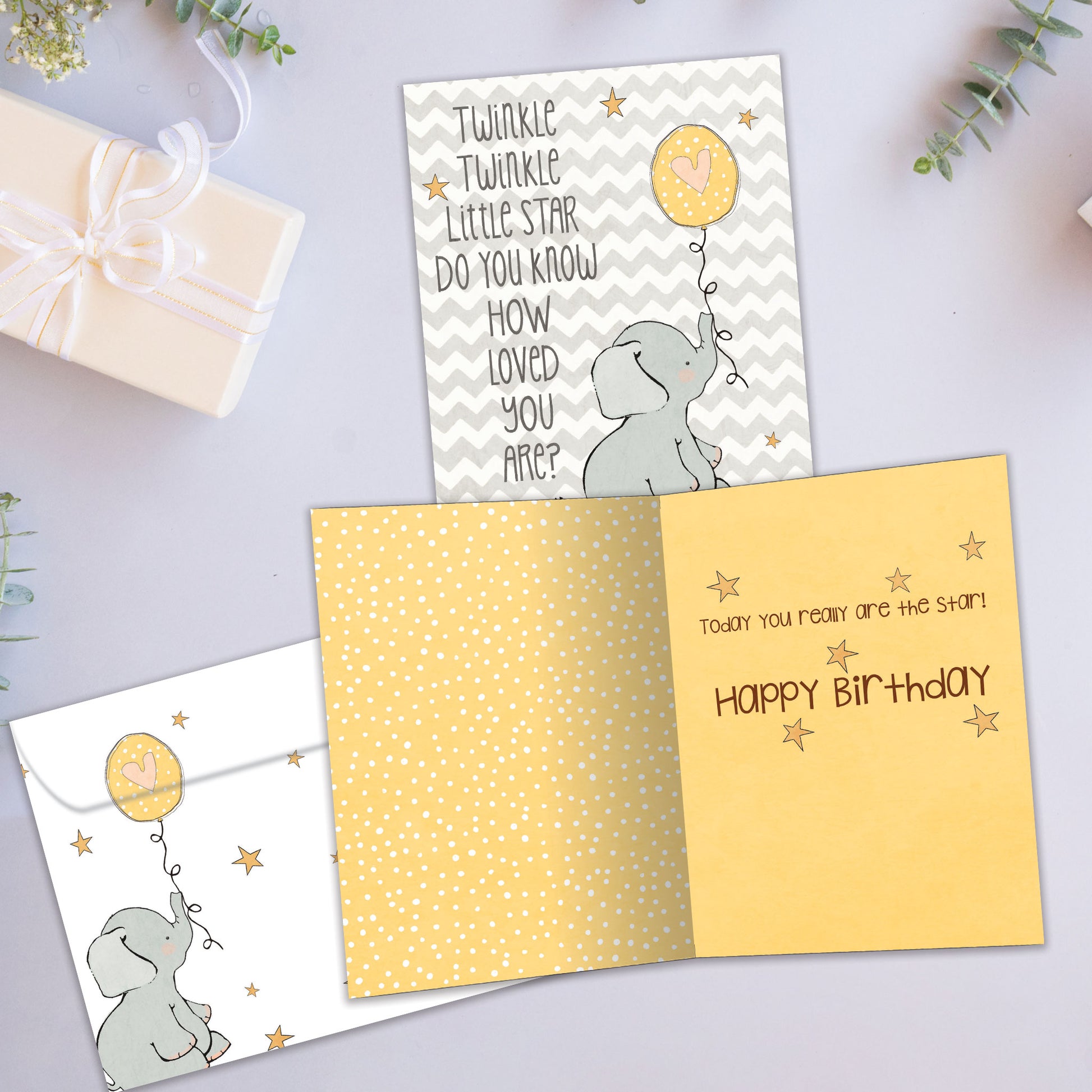 Front and inside view of a Birthday greeting card showcasing an illustration of a baby elephant holding a balloon, with a matching envelope.