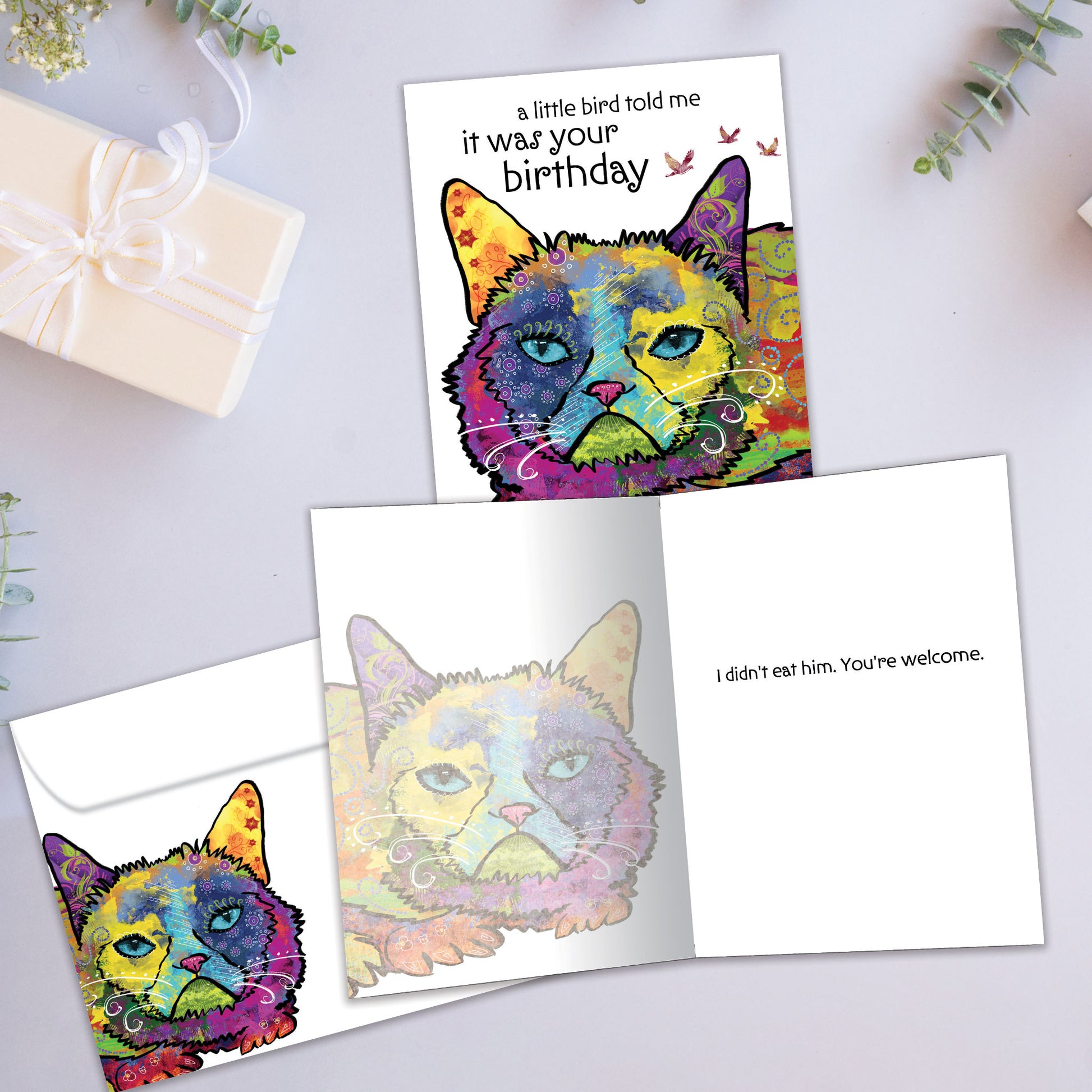 Front and inside view of a Birthday greeting card showcasing a colourful cat illustration with a birthday message, with a matching envelope.