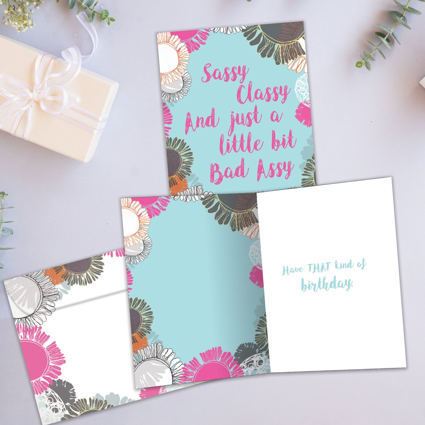 Front and inside view of a Birthday greeting card showcasing the message "Sassy classy and just a little bit bad assy," with a matching envelope.
