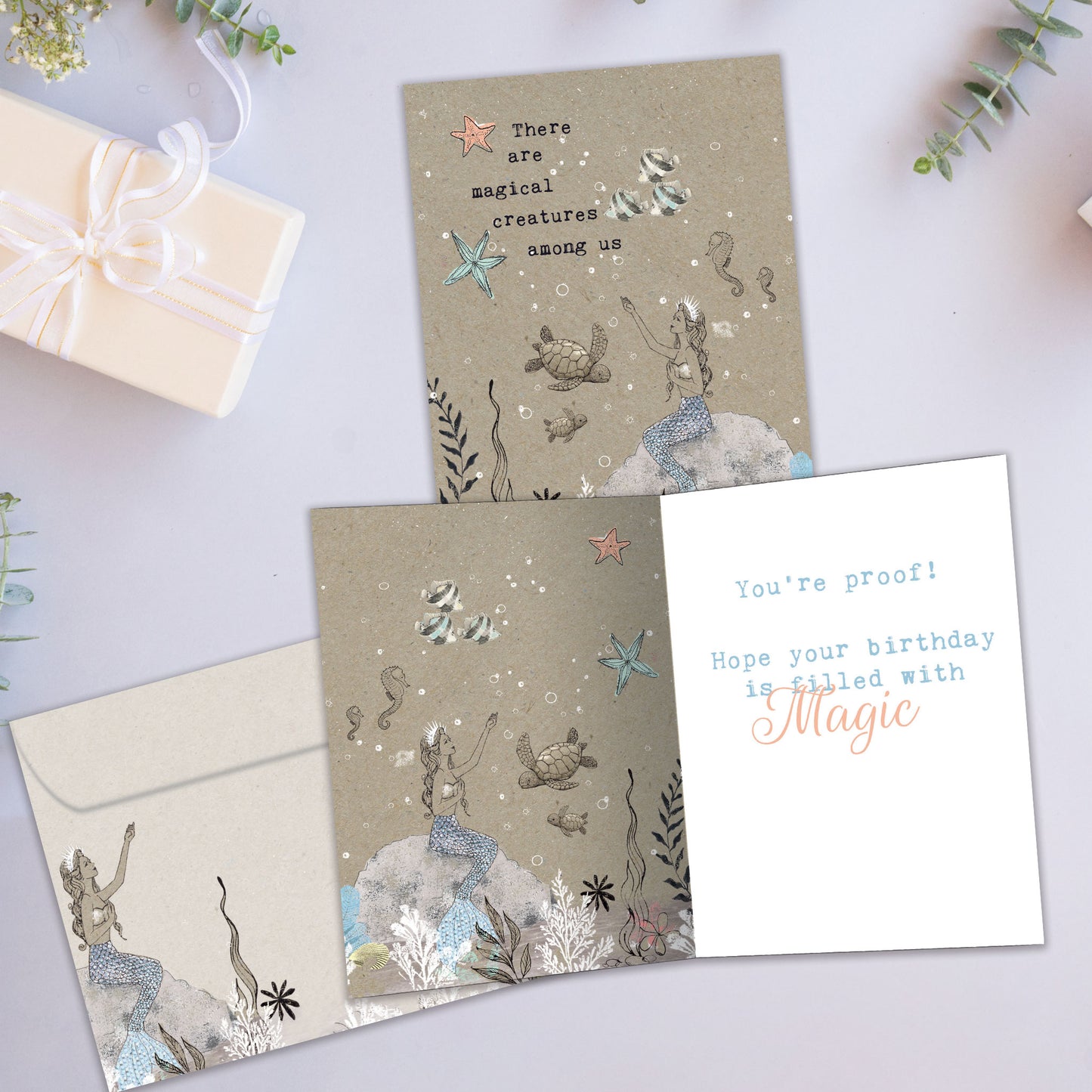 Front and inside view of a Birthday greeting card showcasing a mermaid and sea creatures in a magical setting, with a matching envelope.