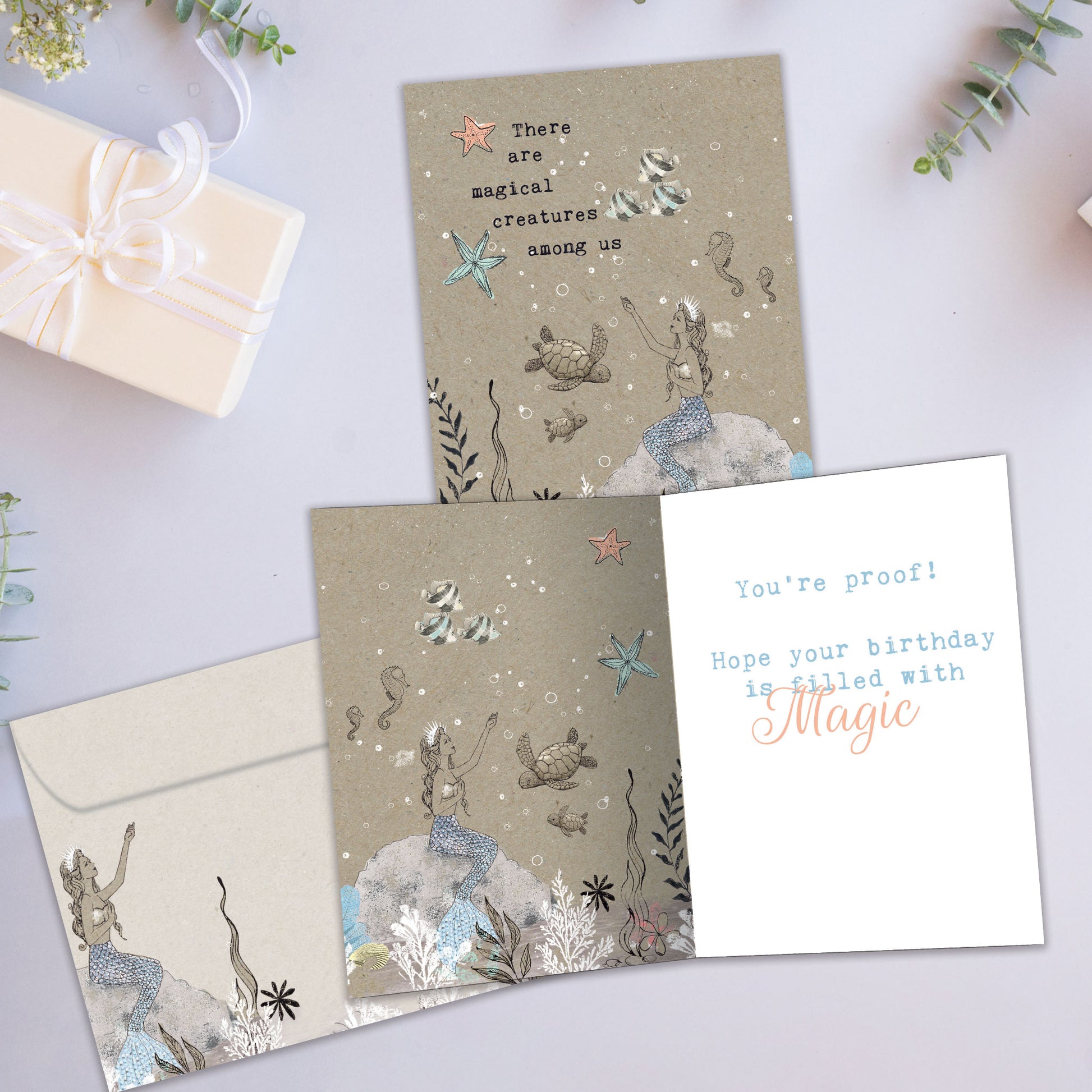 Front and inside view of a Birthday greeting card showcasing a mermaid and sea creatures in a magical setting, with a matching envelope.