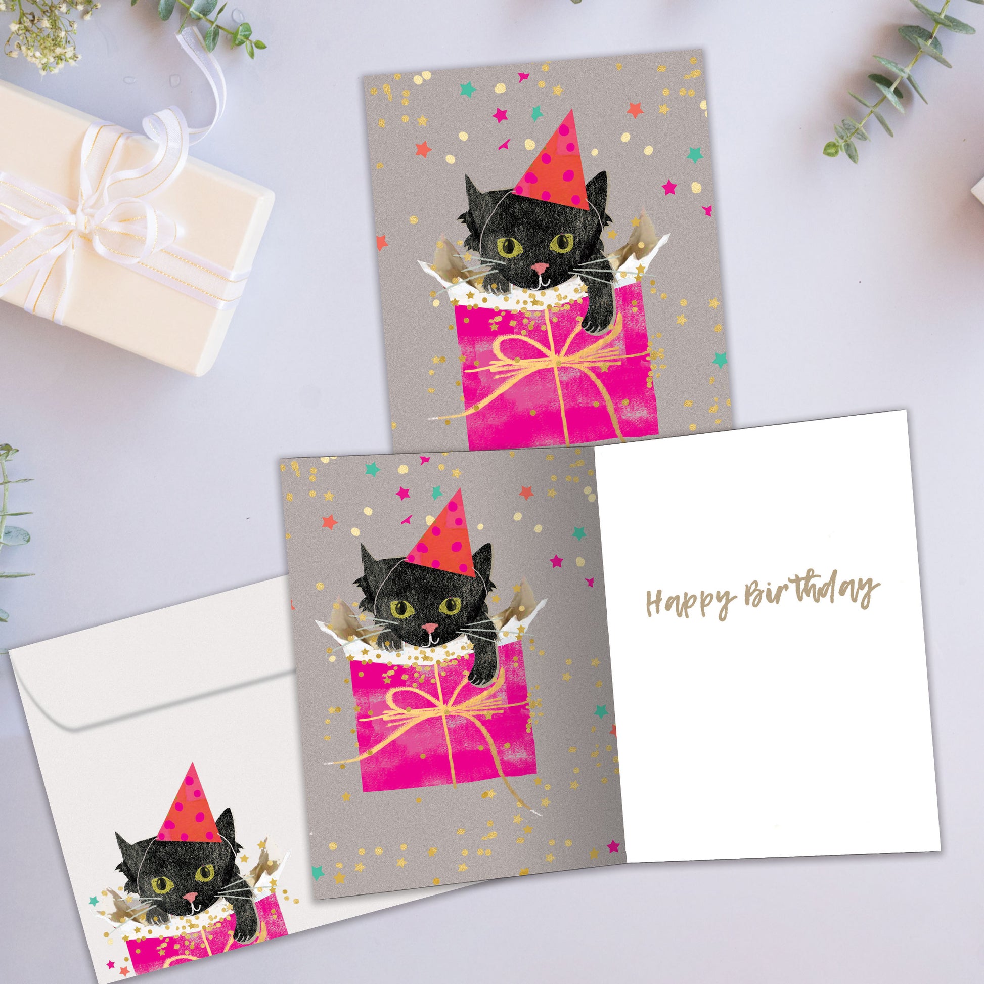Front and inside view of a Birthday greeting card featuring a kitten in a gift bag wearing a birthday hat, with a matching envelope and cheerful details.