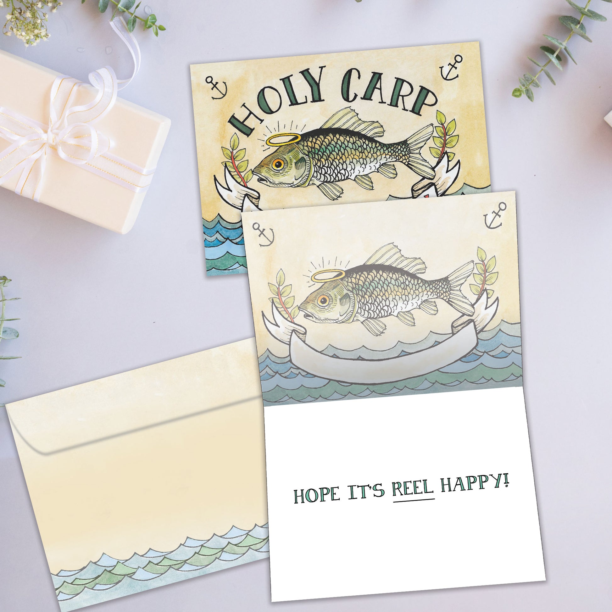 Front and inside view of a Birthday greeting card featuring a fish and the message "Holy carp. It's your birthday", with a matching envelope.