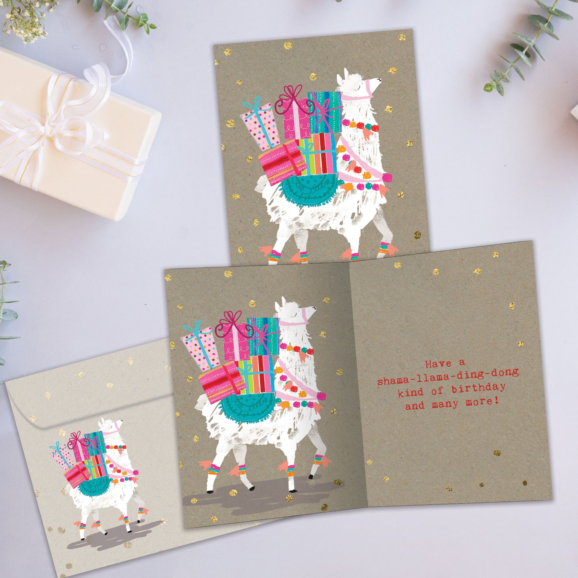 Front and inside view of a Birthday greeting card showcasing a llama carrying birthday presents on its back, with a matching envelope.