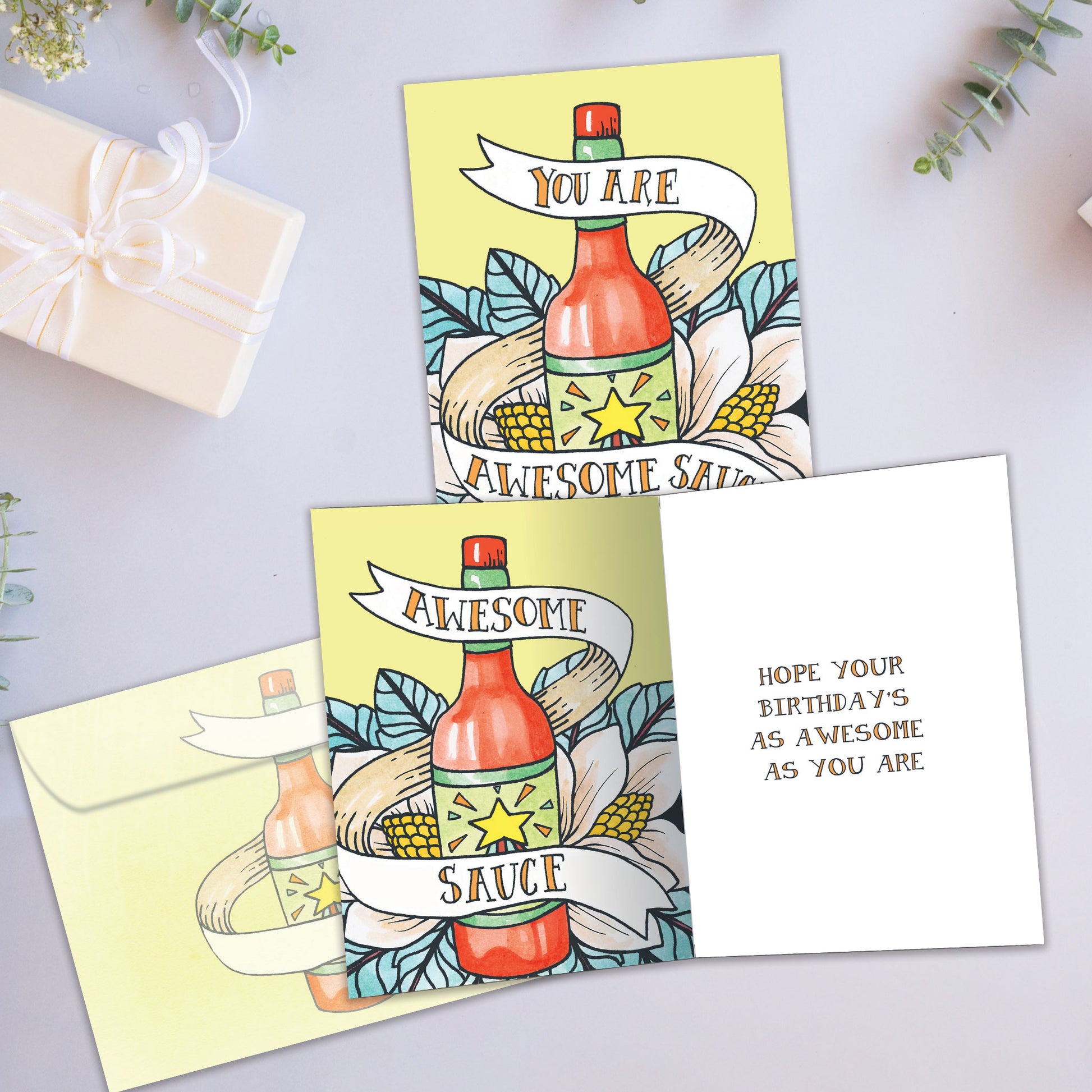 Front and inside view of a Birthday greeting card showcasing a bottle of sauce with the message "You are awesome sauce," with a matching envelope.