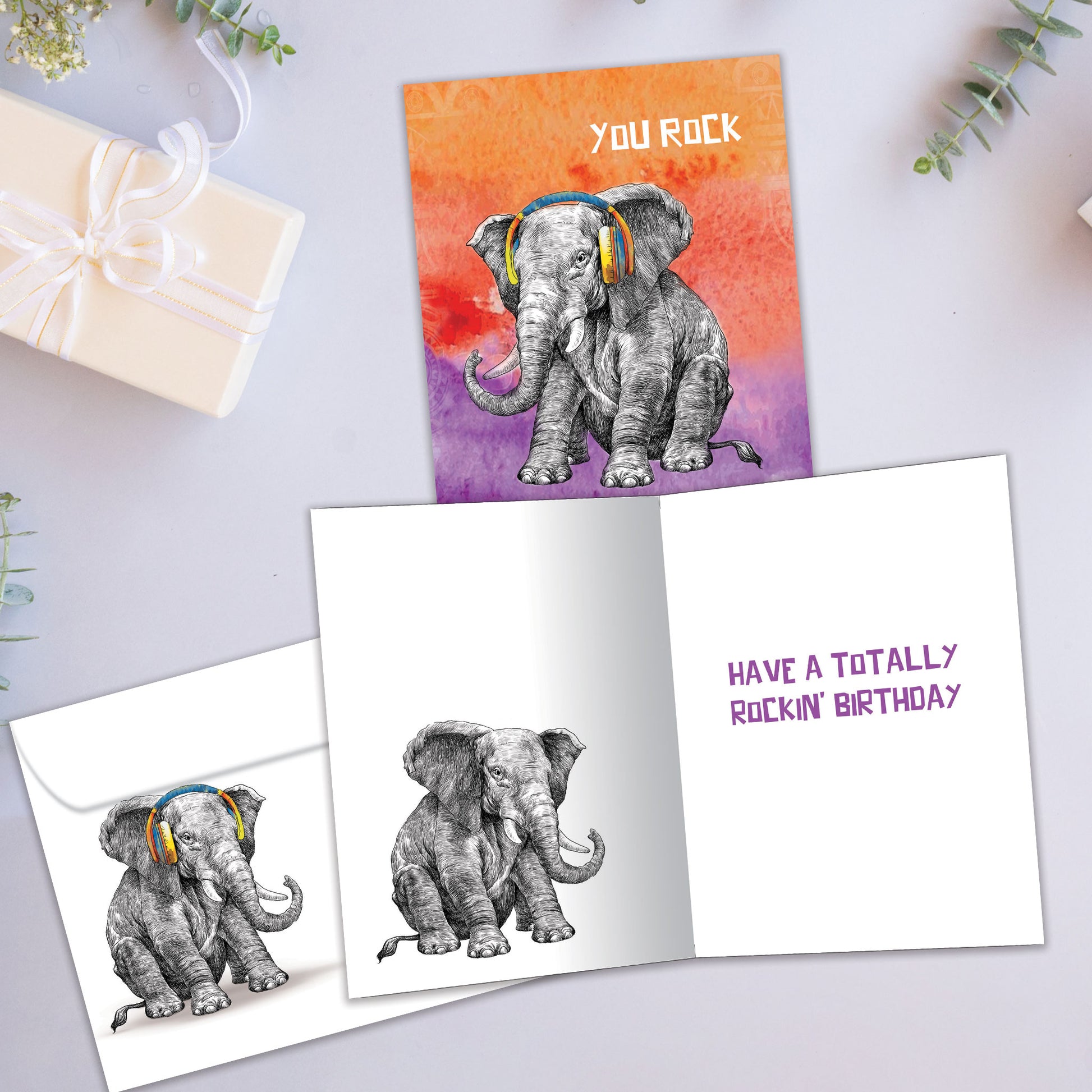 Front and inside view of a Birthday greeting card featuring an elephant with headphones and the message "You rock," with a matching envelope.